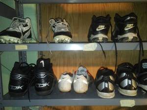 lot 842 image: 2 dozen pair Football shoes and metal rack  various sizes Under Armour, Nike, Adidas and more.