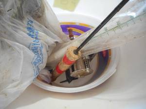 Bucket of Pipe Fittings, Fishing Poles, Heat Light Bulb, etc