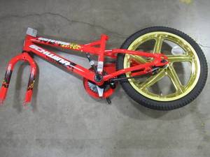 lot 313 image: Incomplete 18 Red Boys Mototrax by Schwinn With Mag Wheels - Missing Training Wheels, Seat, Pedals, Front Wheel, Handle Bars and Chain. S0803WMDS.