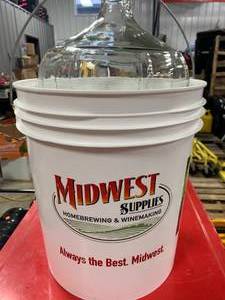 lot 93 image: Wine Making Supplies - 6 Gallon Glass Carboy & 7.8 Gallon Bucket