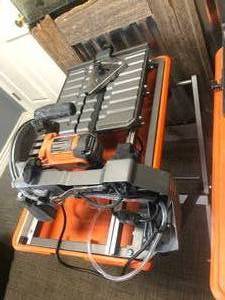 lot 63 image: RIDGID 9 Amp Corded 7 in. Wet Tile Saw with Stand in working conditions