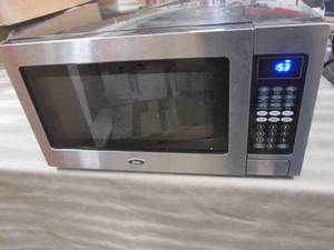 lot 124 image: Oster 1.1 cu ft Microwave open box,...