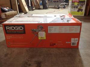 lot 38 image: RIDGID 9 Amp Corded 7 in. Wet Tile Saw with Stand not used WHIT SMALL DAMAGE IN WATER TRAY