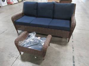 lot 400 image: Hampton Bay Cambridge Brown Wicker Outdoor Sofa with Blue Cushions With Ottoman - Two Cushions may need re-upholstering.