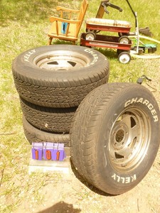 lot 101 image: 1970s GM wheels & tires. 4 12 bolt pattern. Approx 30% tread. 22570r14. As shown.