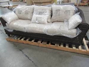 lot 403 image: Home Decorators Collection Camden Dark Brown Wicker Outdoor Sofa with Sunbrella Antique Beige Flax Cushions FRA60624ATVWP - BACK BOTTOM HAS A COUPLE DENTS.
