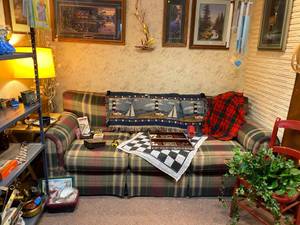 Cabin Set up with couch, games, matted pictures, lamp, camp popcorn popper and more