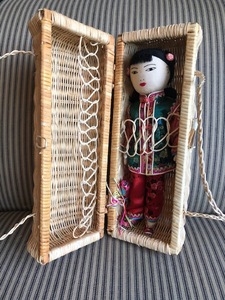 lot 209 image: Asian Doll With Wicker Case And Multiple Outfits
