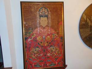lot 2 image: A Chinese late Qing dynasty ancestor portrait showing the wife of an Emperor  in brightly colored dragon decorated robe  China, late 18th Century