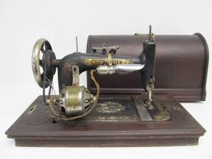 lot 66 image: Antique NEW HOME Sewing Machine wDome Top Wood Case