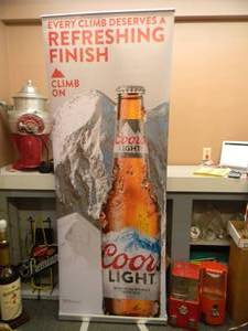 lot 24 image: COORS LIGHT - Retractable display banner stand  easy to set up and take down OR CAN BE HUNG - LARGE VERY COOL APPROX 30 X 80 - SEE PICTURES