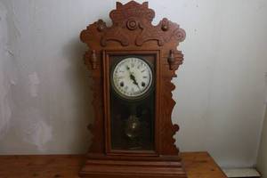 lot 1 image: Antique Waterbury Gingerbread 8 Day weather station calendar shelf clock with key.