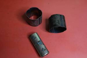 lot 63 image: Lot including metal lighter cover with crushed turquoise and pair of ornate silverplate napkin rings