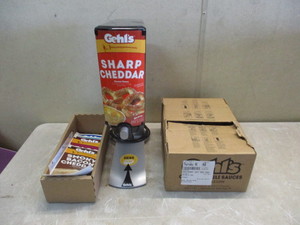 lot 6 image: Gehls 2.0 Sauce Dispenser with 4 unopened bags of Sharp Cheddar (Good Lot Code). Comes with extra Faceplate Stickers.