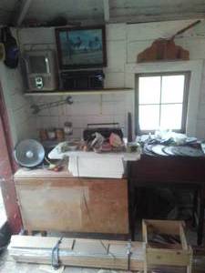 lot 145 image: Drop Leaf Table with contents, heater, radio, bundled wood and more.