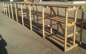 lot 395 image: Heavy Duty Wood Shelving unit 32 feet long. Bring  some tools to split them.