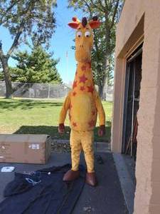 lot 44 image: Geoffrey Giraffe Costume (Like New In Box) 2-Onboard Fans & Light (Model Is A Slender 6 Male)