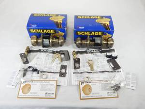 lot 212 image: Set of 2 New Schlage F51 Antique Brass Keyed Entrance Door Knob Sets