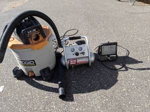 lot 212 image: Rigid 12 Gallon Shop Vac, Grip Rite 1 Gallon Air Compressor, Portable Clamp Spotlight