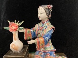 Asian Girl Figurine Sits on a Rug
