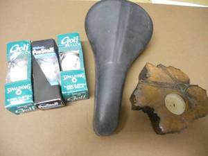 lot 124 image: 3 boxes of golf balls, bike seat, Wood tea light candle holder
