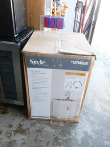 lot 13 image: Style laundry cabinet. 24 x 21 x 50. Basesinkfaucet included. Appears new in box. As shown.