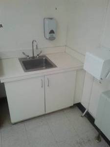 Sink, cupboard, paper towel and soap dispensers, plus other closet.