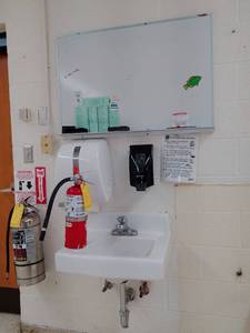 2 Fire Extinguishers, sink, paper and soap dispensers, white board.
