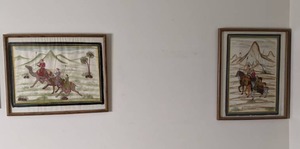 lot 100 image: Pair of Painted Fabric Framed Art Pieces Riders on Horses and Camels