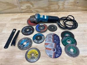 lot 34 image: MAKITA 7.5 Amp Corded 4-12 in. Easy Wheel Change Compact Angle Grinder with Grinding Wheel With a Variety of Cutting Wheels.