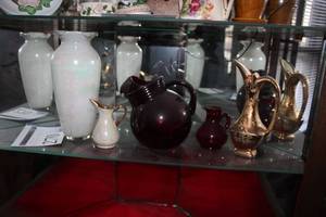 lot 270 image: Lot of (5) Decorative White with pastels Ceramic Vase and Matching Small Pitcher, Red Glass Water Pitcher and Matching Small Red Glass Creamer Pitcher, Ornate Pitcher