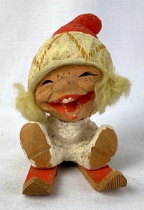 lot 91 image: Henning Hand-Carved Norwegian Wooden Figure of Little Blonde Toddler Sitting on Red Skis - Snowflake