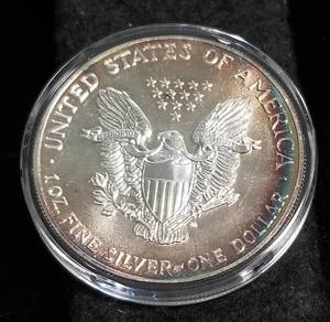 lot 14 image: 1988 AMERICAN SILVER EAGLE 1 TROY OZ. .999 FINE SILVER IN AIRTITE BEAUTIFUL TONING