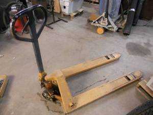 lot 121 image: Pallet Jack - Pump needs repair, jacks up a bit, situation with pump, rolls good, could be converted to snowmobile dolly