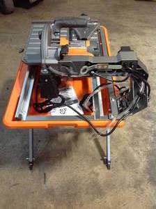 lot 25 image: Ridgid 9 Amp Corded 7 in. Wet Tile Saw with Stand see pictures
