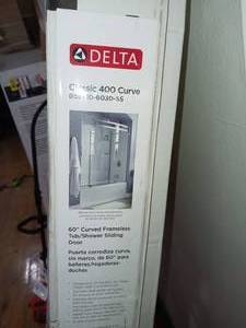 lot 49 image: Classic 400 Curve 60 in. x 62 in. Frameless Sliding Tub Door in Stainless by Delta- open box not used