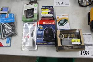 lot 198 image: Lot of (6) Small Electronics (in package) - Mini Amp Speaker, Honeywell Portable Fan, Worldwide Adapter USB Charger, Computer Mouse, AC Adapter, 50W Step-Up International Transformer