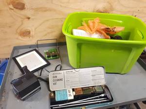 lot 739 image: Gun Cleaning Kit, Polaroid Camera, Old Cell Phones and More in Tote
