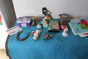 lot 300 image: Lot of Christmas Dcor - Bell, A Christmas Story VHS Movie, Tin, Horseshoe, Coasters, And More