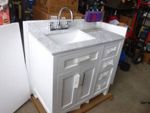 36 OVE Tahoe vanity with marble Top & faucet. $1000 at Lowes. Box was opened for the 1st time to take pictures for this auction. Has a tiny chip in top. As shown. THIS ITEM HAS A RESERVE.