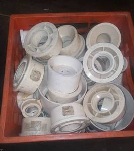lot 24 image: Milk crate with pvc plumbing connectors