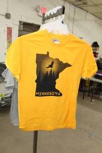 lot 221 image: Lot of (4) Noble Wear T-Shirt Small 90% Cotton 10% Polyester Yellow (x3), Gold(x1) with Minnesota Logo (new)