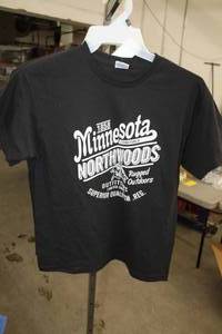 lot 329 image: Lot of (6) Delta Pro Weight T-Shirt Youth X-Large 100% Cotton Black with Minnesota Northwoods 1858 Logo (new)