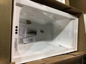 lot 15 image: Pallet with American STD EverClean 60 in.  Whirlpool Bathtub in White and  Alcove Tub Surround in White see pictures