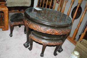 lot 4 image: Decorative Wood End Table 32D with Glass Top Over Elaborate Jousting Match Carved Top with Hide-Away Decorative Wood Triangle Chairs (x4)