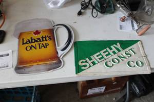 lot 86 image: Lot of (2) Signs - Sheehy Const Co Metal Sign, Labatts On Tap Plastic Sign