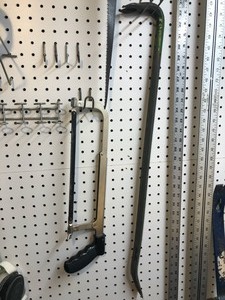 Various tools, pegboard hooks, and 2 hats