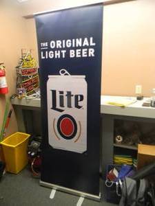 lot 31 image: MILLER LITE THE ORIGINAL LITE BEER - Retractable display banner stand  easy to set up and take down OR CAN BE HUNG - LARGE APPROX 30 X 80 - SEE PICTURES