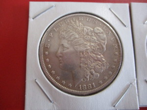 1881-O (New Orleans Mint) Morgan Silver Dollar and 1922-S Peace Silver Dollar.