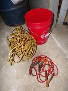 Pail with jumper cables and extension cords